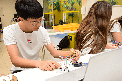 Aula de Robótica - alunos trabalhando com eletrônicos